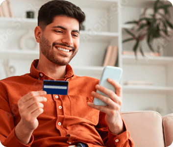 Ragazzo sorridente che paga dal telefono con la carta
