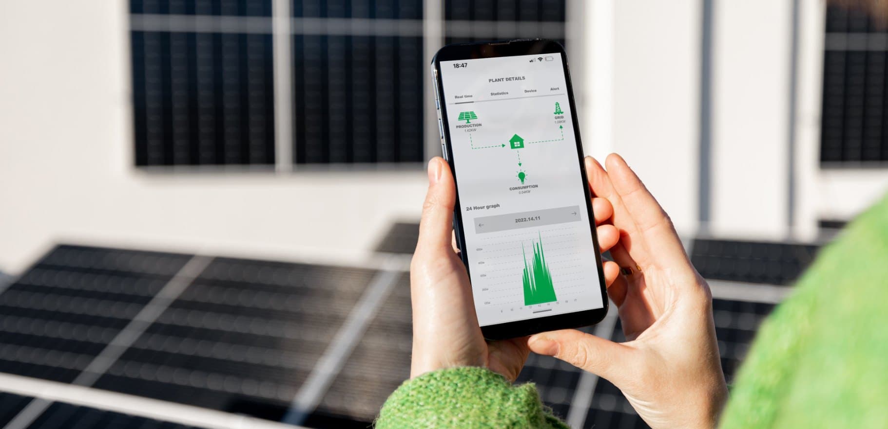 Smartphone con il grafico dei consumi davanti a pannelli solari